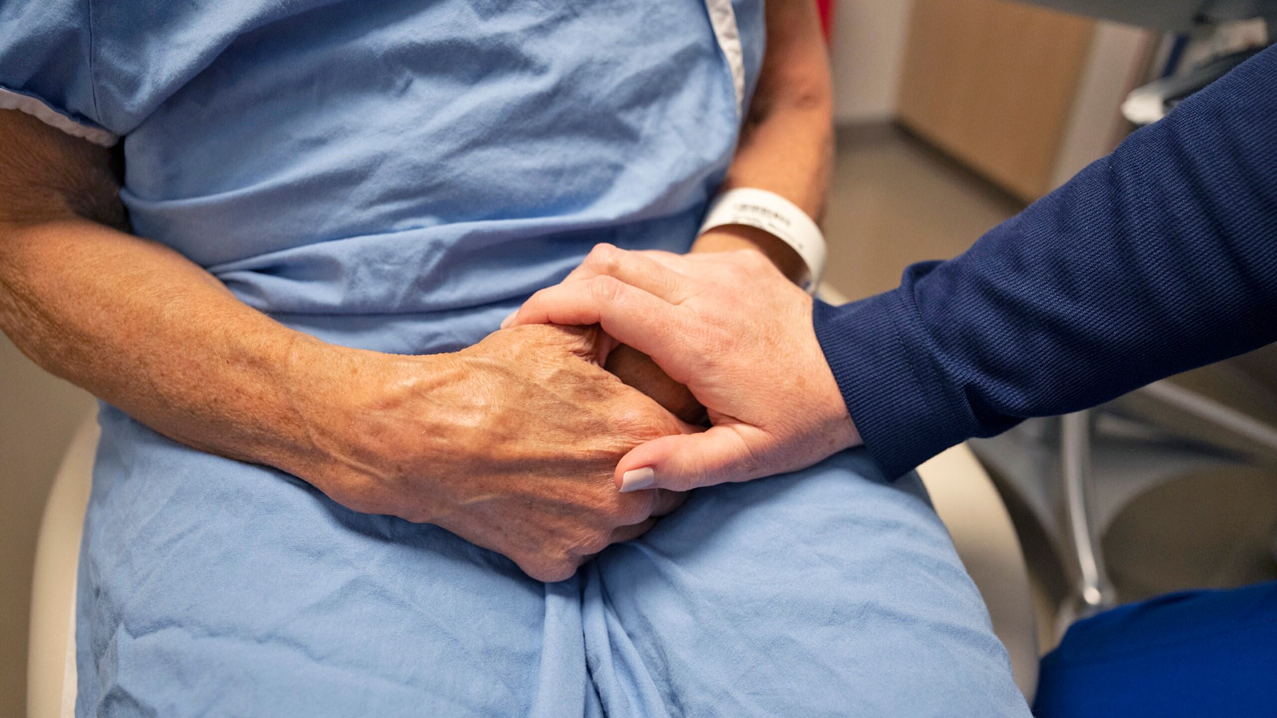 Patient holding hands with their doctor.