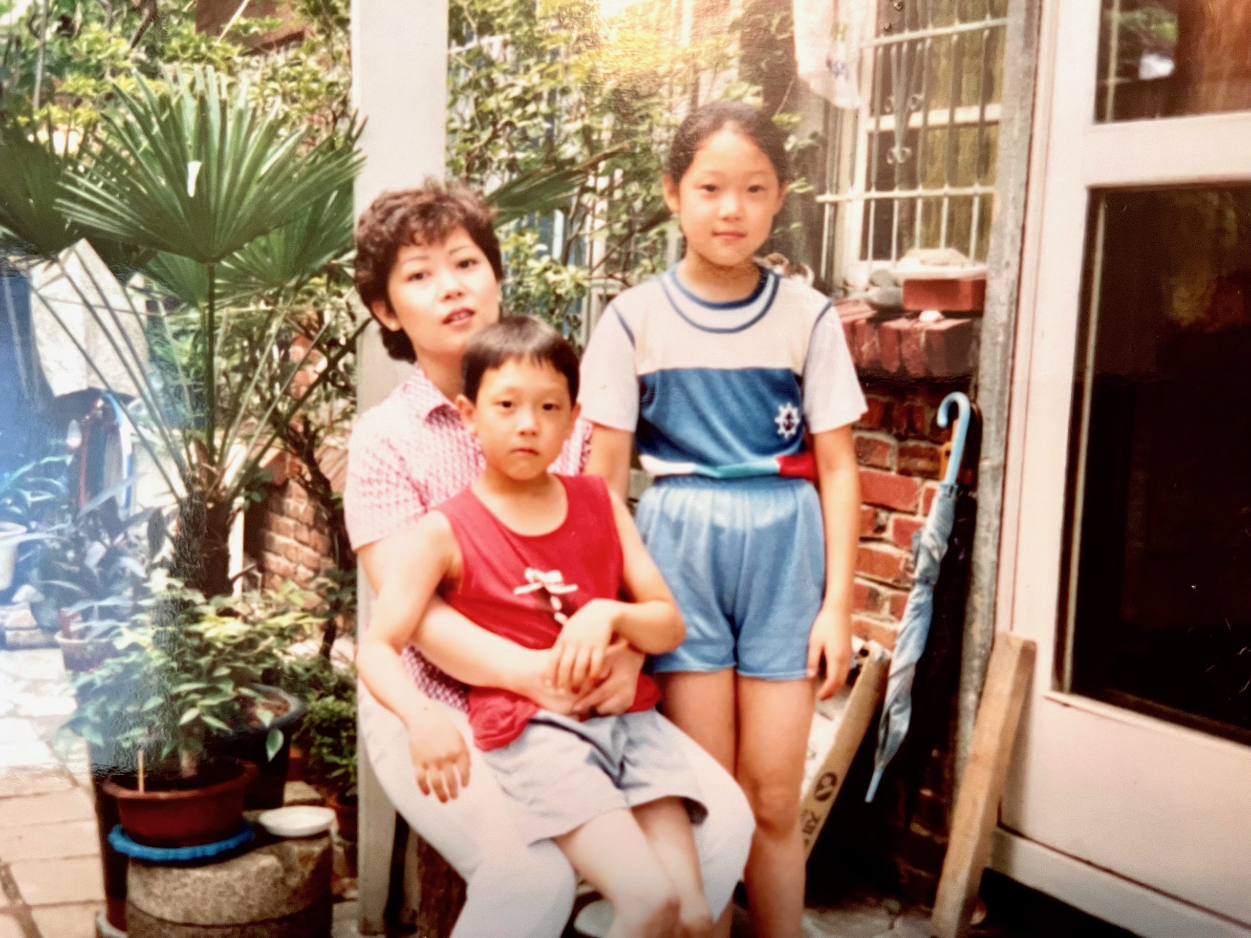 Young boy and girl with their mother, sitting on a chair