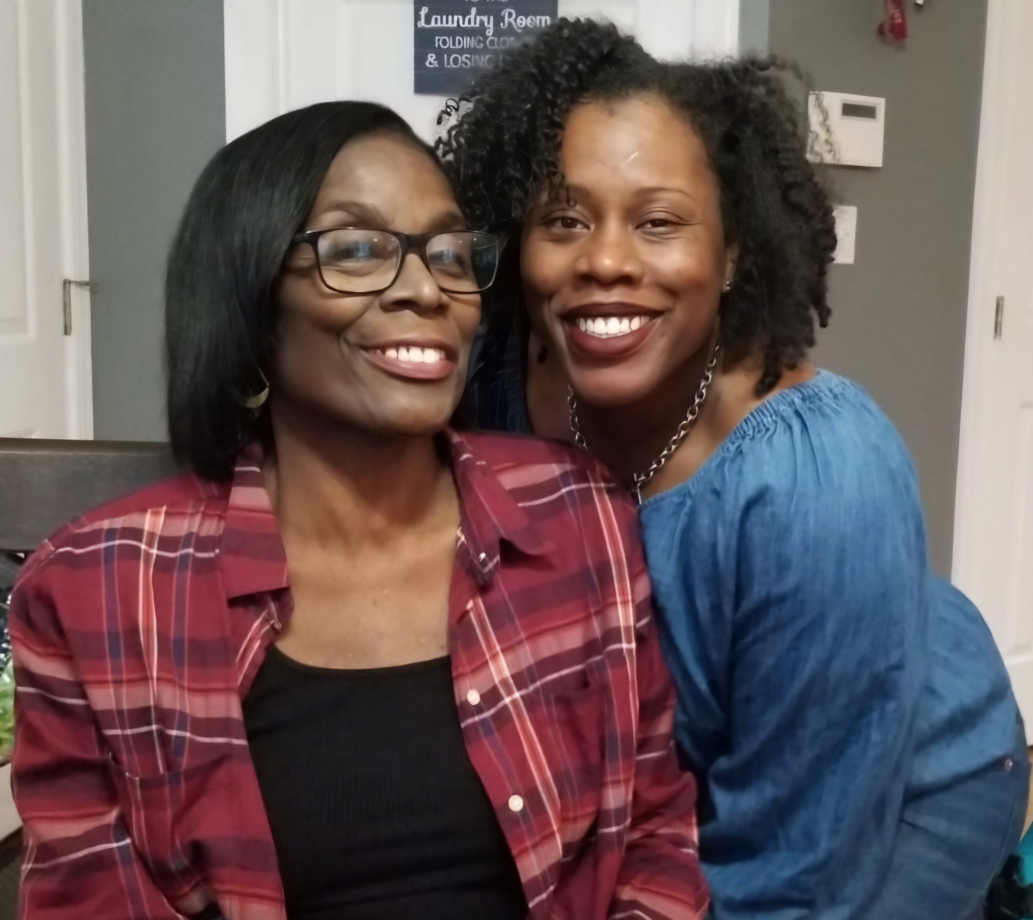 African American mother and daughter smiling for camera.