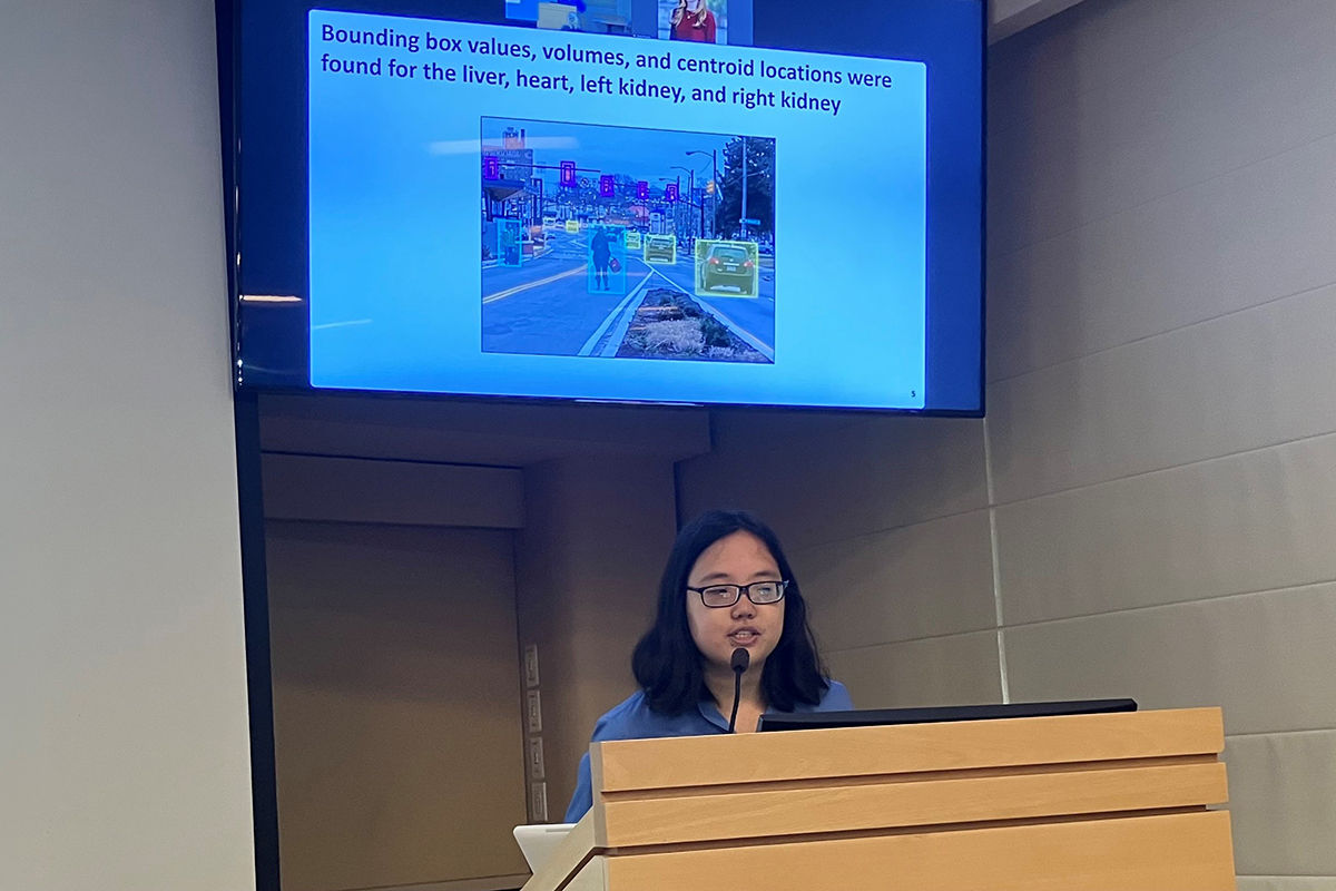 Young Asian-American woman presenting at podium.