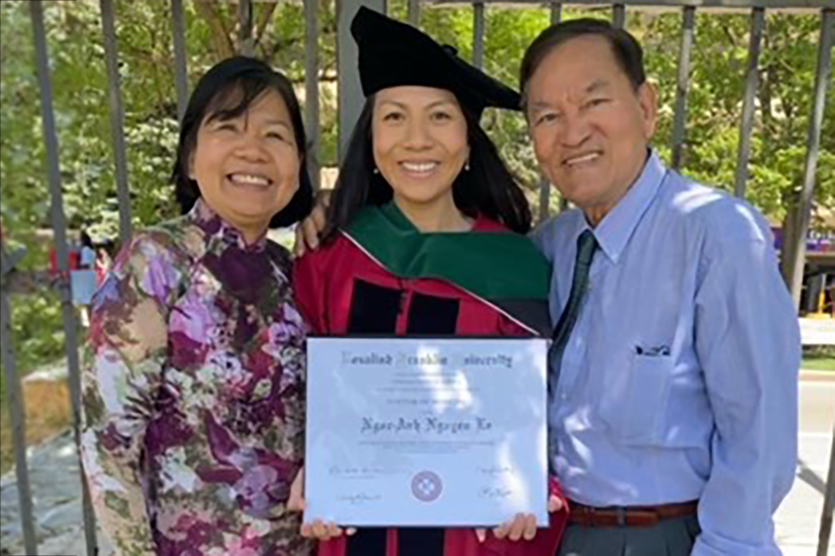 Young woman with parents at graduation.