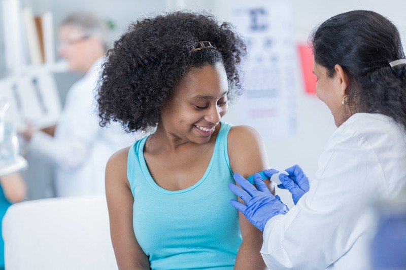 Doctor putting a band-aid on a girl's arm