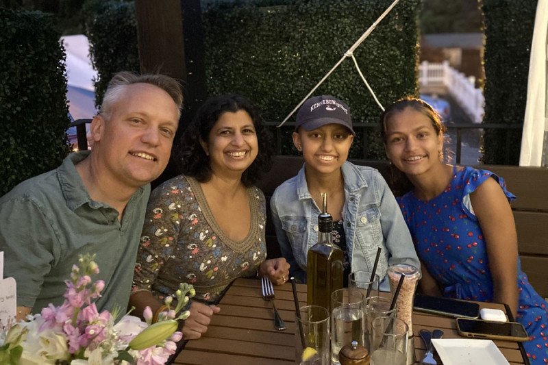 Sona with three family members at a dinner table