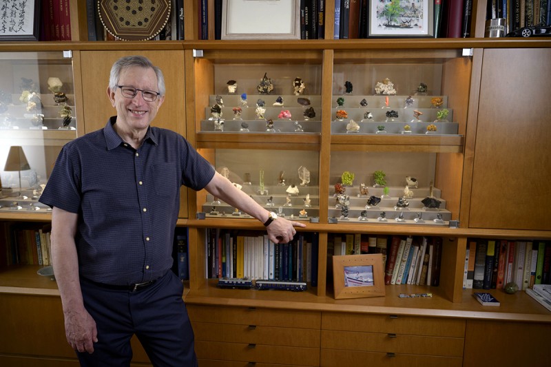 Joan Massagué stands in front of his mineral collection