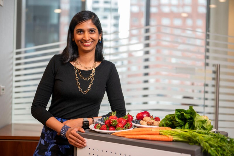 MSK hematologic oncologist Dr. Urvi Shah poses smiling with fresh fruits and vegetables that are high in magnesium.