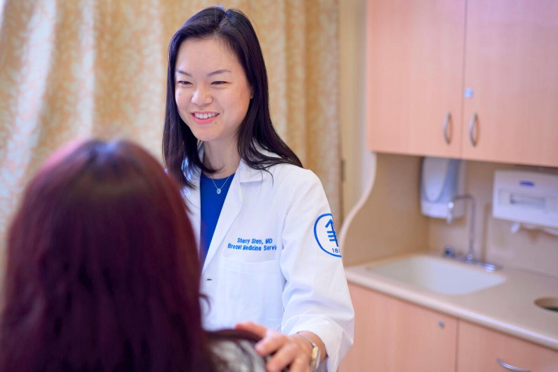 MSK breast oncologist Dr. Sherry Shen places her hand on a patient's shoulder during an appointment