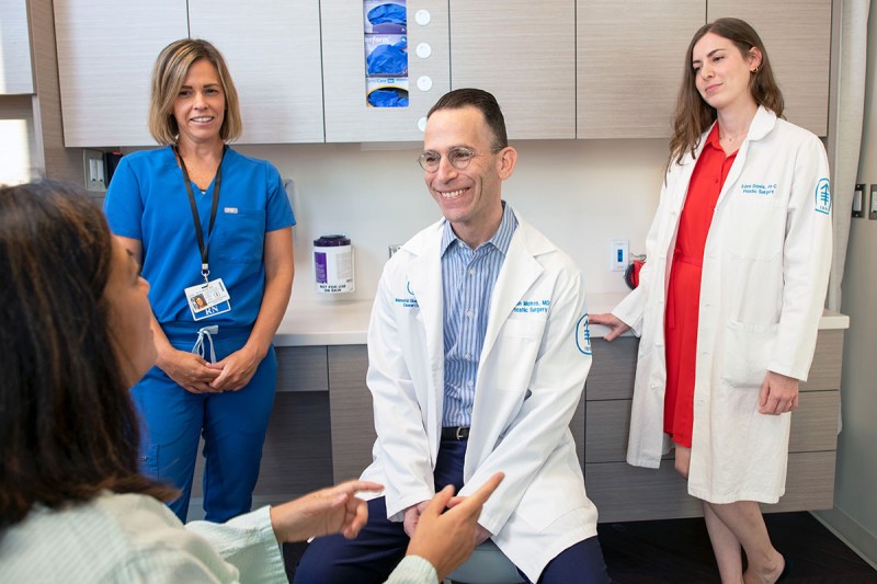 临床护士 Jennifer Fox、医学博士 Evan Matros 和医生助理 Eden Davis 与一名患者会面。