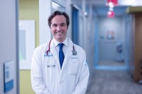 MSK thoracic oncologist Robert Daly, MD, MBA is seen standing in a clinic hallway. 