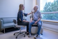 MSK social worker Sabrina Feldman places a reassuring hand on patient Bobbie Walker's shoulder as they talk 