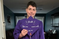 Cody holds his graduation cap