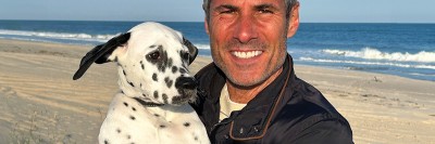 MSK patient Marc Scarduffa seen holding his dog at the beach. 