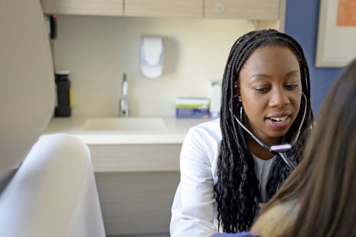 Dr. Chidi examining thoracic patient with stethoscope.